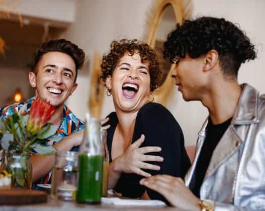 3 people laughing in a restaurant.