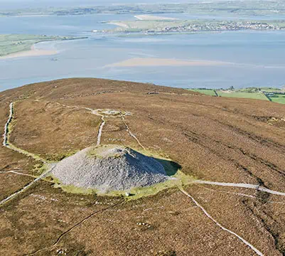 image of Queen Maeve's tomb from the air, a monumental burial mound on top of a mountain