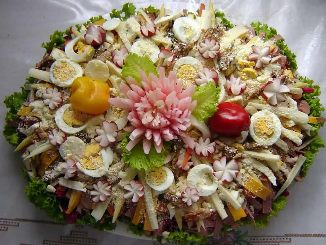 Traditional fiambre salad with hard boiled eggs, radishes, cheeses, cold-cut meats, lettuce, sweet peppers, and other ingredients.